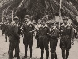 Dalam foto ini tampak para rekrutan PETA sedang bercengkerama, sementara di latar belakang terlihat seorang perwira dinas mingguan yang sedang bertugas.